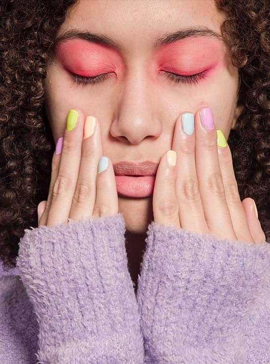 Imagen - Mujer manos en la cara, ojos pintados de rojo, uñas de colores, pelo ondulado - JP Cosmetics - Produtos Digitais